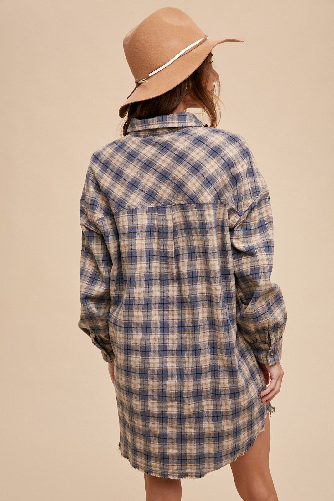 back view of Button-up plaid shirt dress with breast pockets and button closures on cuffs. Made from 60% cotton and 40% polyester. Can be worn as a dress or shacket.