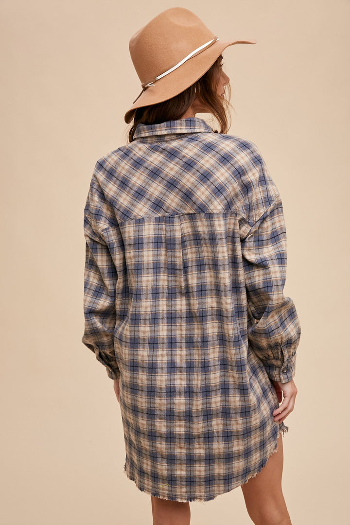 back view of Button-up plaid shirt dress with breast pockets and button closures on cuffs. Made from 60% cotton and 40% polyester. Can be worn as a dress or shacket.