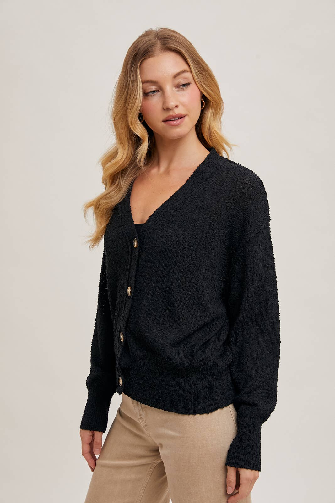 slight side view of Black Betty Button-Down Cardigan with a classic button front, relaxed fit, and long sleeves, made from soft knit fabric for cozy layering, available at Onyx Native.