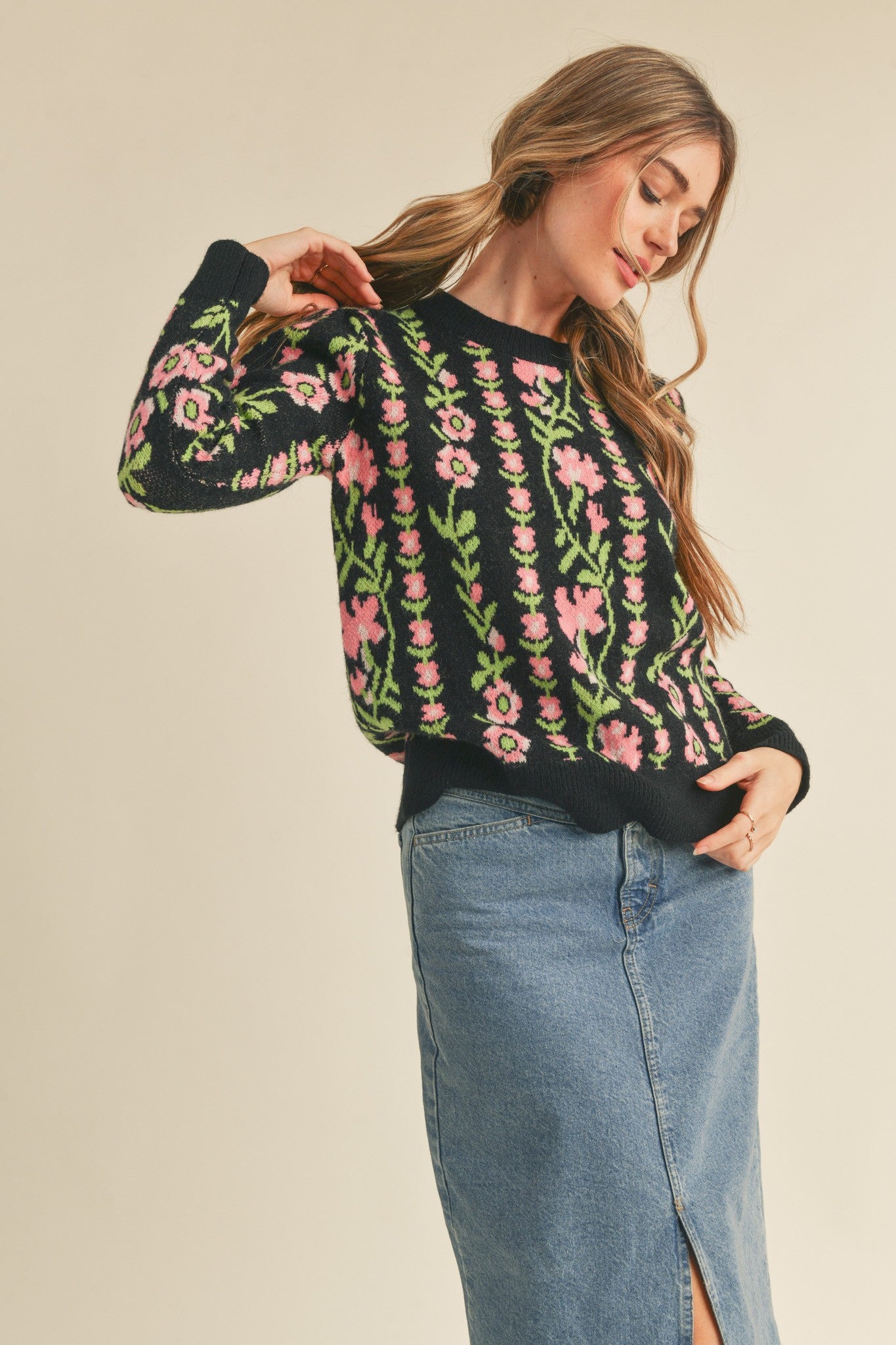 slight side view of Black Betty Floral Knit sweater with a floral knit pattern. Features a ribbed round neckline, ribbed edges, and a relaxed fit.