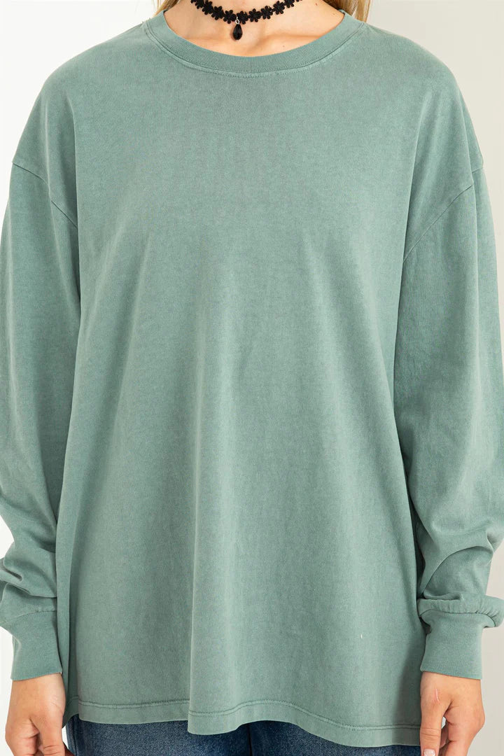 Trendy oversized T-shirt with a classic round neck, drop shoulders, and long sleeves. Features ribbed edges and is made from 100% cotton. Model is 5'9" with a 32" chest, 23" waist, and 35" hips, wearing a size Small. The T-shirt is available in an oversized fit, ideal for a relaxed look