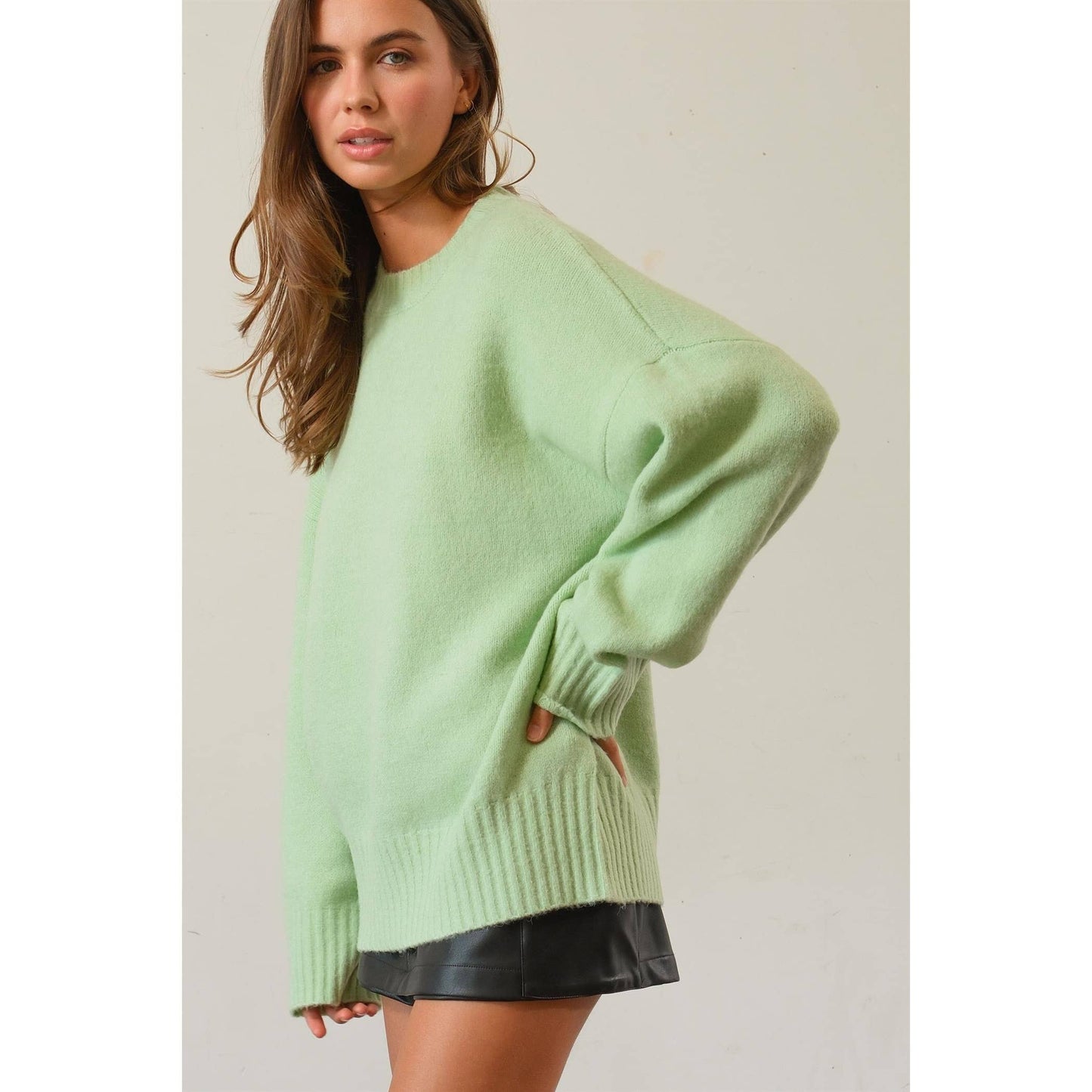 slight side view of Jade Oversized Sweater Pullover with dropped shoulders and ribbed crew neckline.