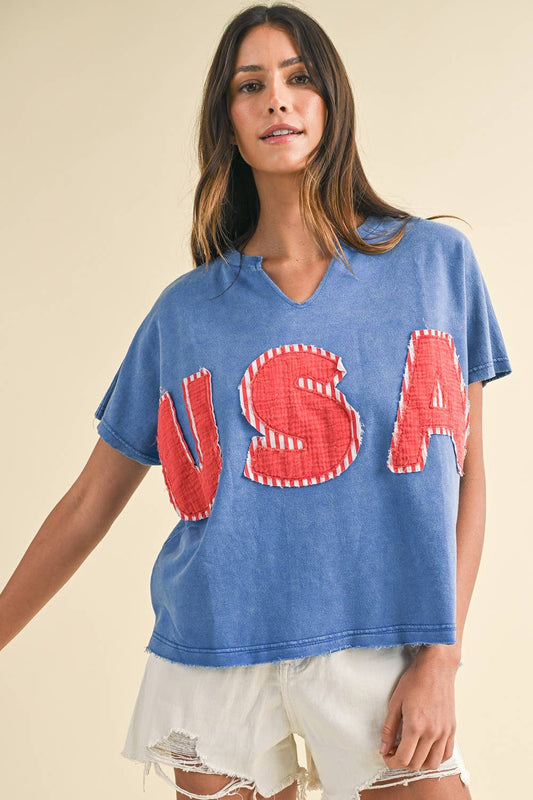 Mineral Washed USA Patched Knit Top with mixed fabric lettering patch, lightweight French terry, notched neckline, short dolman sleeves, raw edge details, and loose fit.