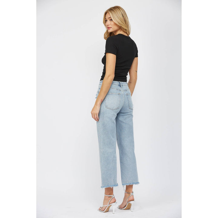 slight back side view of High-rise ankle wide-leg jeans in light wash with minimal distressing. Made from 98% cotton and 2% spandex.