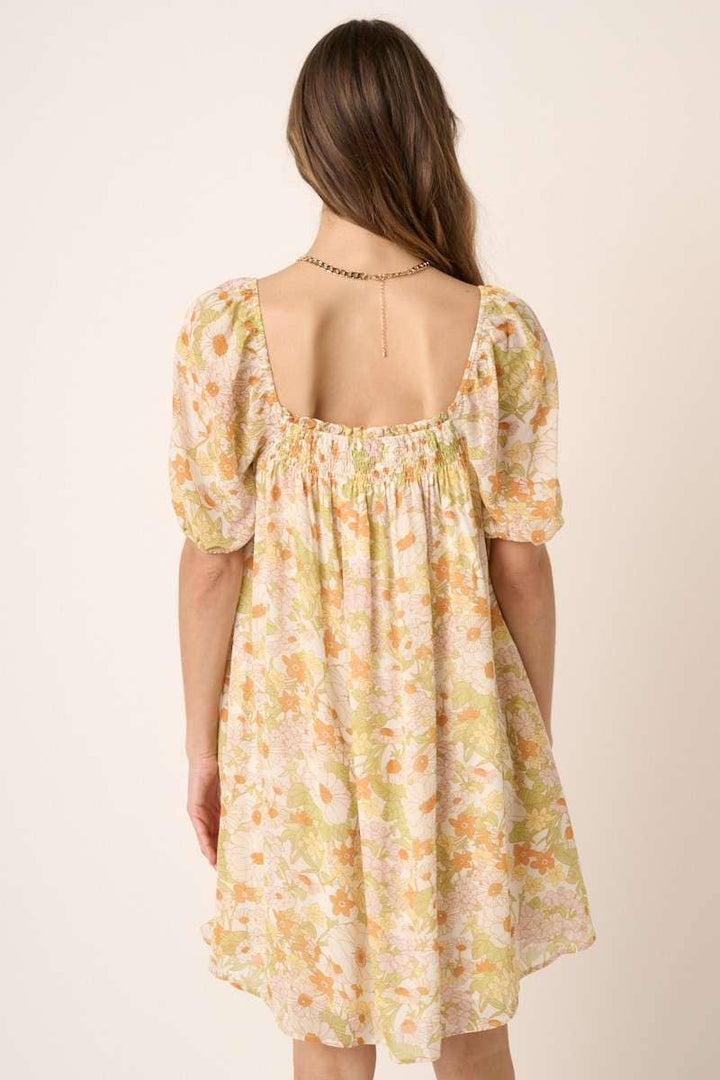 back view of Vintage Flower Print Mini Dress with square neck, short puff sleeves, and tie detail on top. Made from chiffon woven fabric and fully lined. Model is 5'9" wearing size Small.