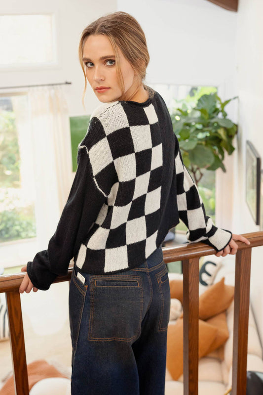 Hit the Track Colorblock Checkered Knit Sweater featuring a boat neckline and long sleeves, made from 100% acrylic, available at Onyx Native.