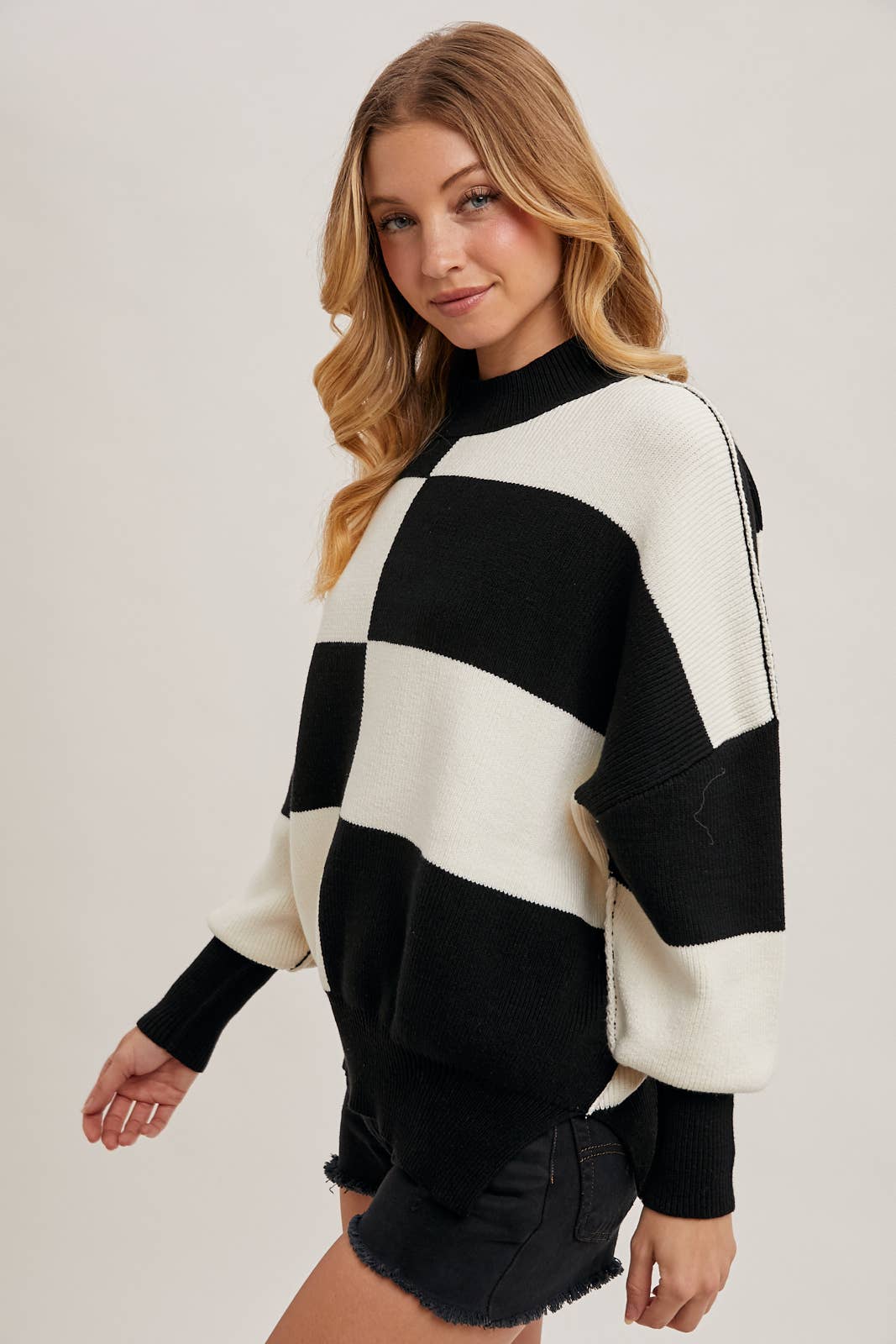 slight side view of Black Color Block Sweater with dolman sleeves, soft knit fabric, and a stylish design, perfect for versatile styling, available at Onyx Native.