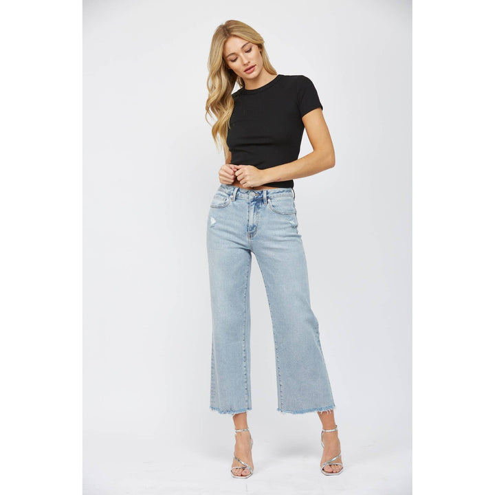 slight side view of High-rise ankle wide-leg jeans in light wash with minimal distressing. Made from 98% cotton and 2% spandex.