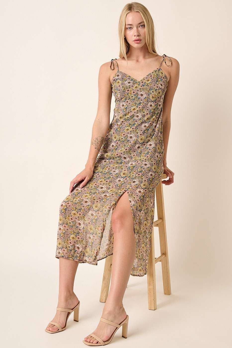 model sitting in Finley Flower Print Side Slit Maxi Dress with a sweetheart neckline, spaghetti straps with tie detail, front and side slit, and maxi length. Lined for comfort. 