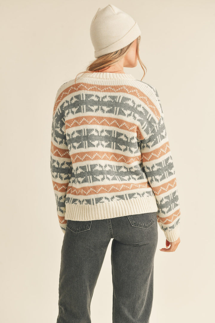 Abstract knit pattern sweater with a ribbed round neck, drop shoulder long sleeves with ribbed cuffs, and an abstract Fair Isle knit design. Features a pullover style and ribbed hem.