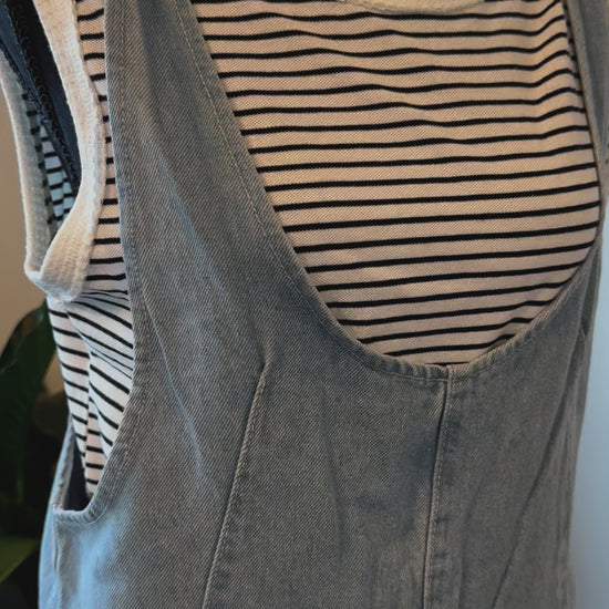 detailed view of Cotton Denim Seam Detail Romper with adjustable straps and front pockets, made of 100% cotton. Available for pre-order with color variations possible due to lighting and monitor differences.