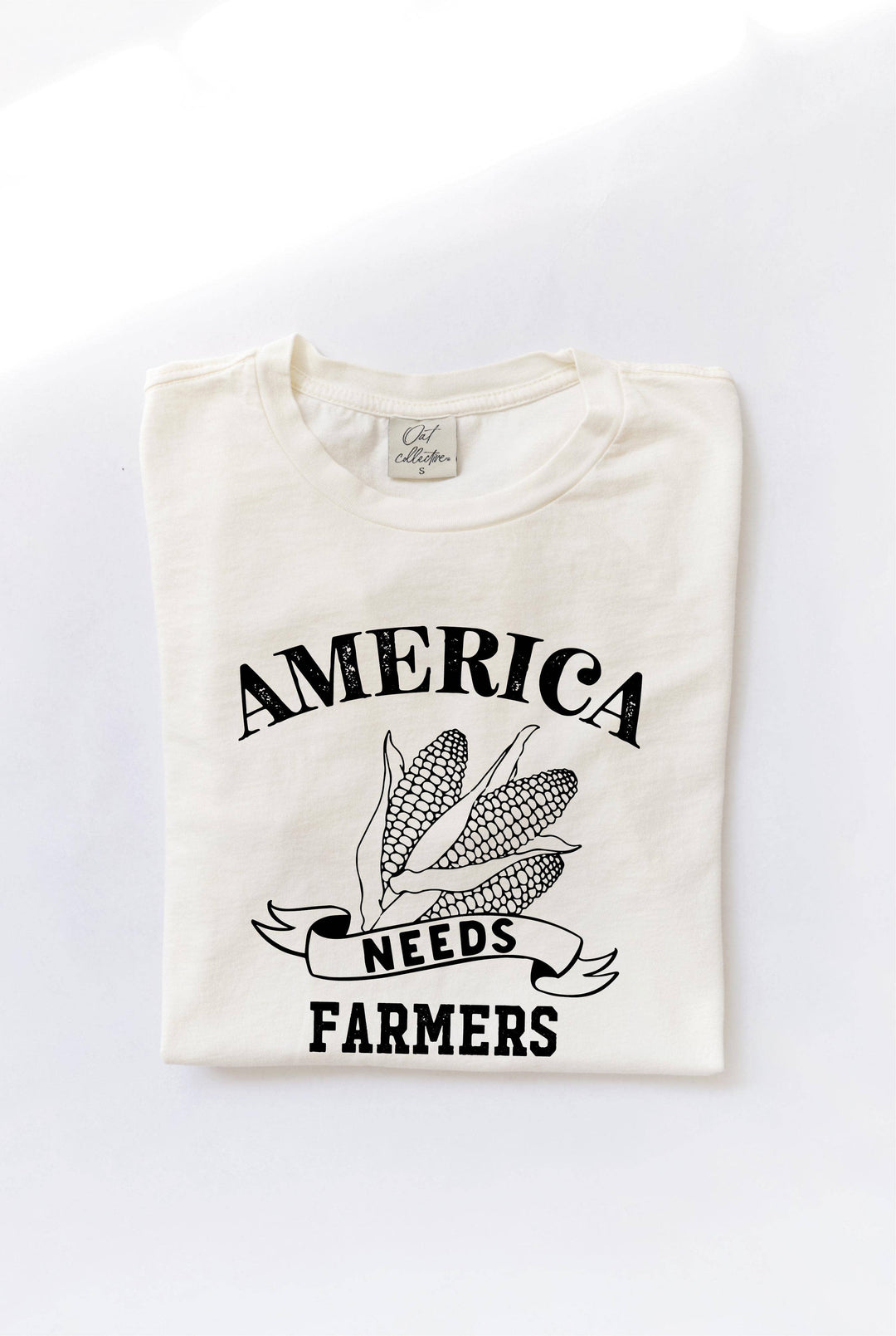 America Needs Farmers mineral washed graphic top in 100% premium cotton jersey. Features a relaxed unisex fit and screen-printed design with water-based ink. Each top is unique due to the dying process. Exclusive Oat Collective label.