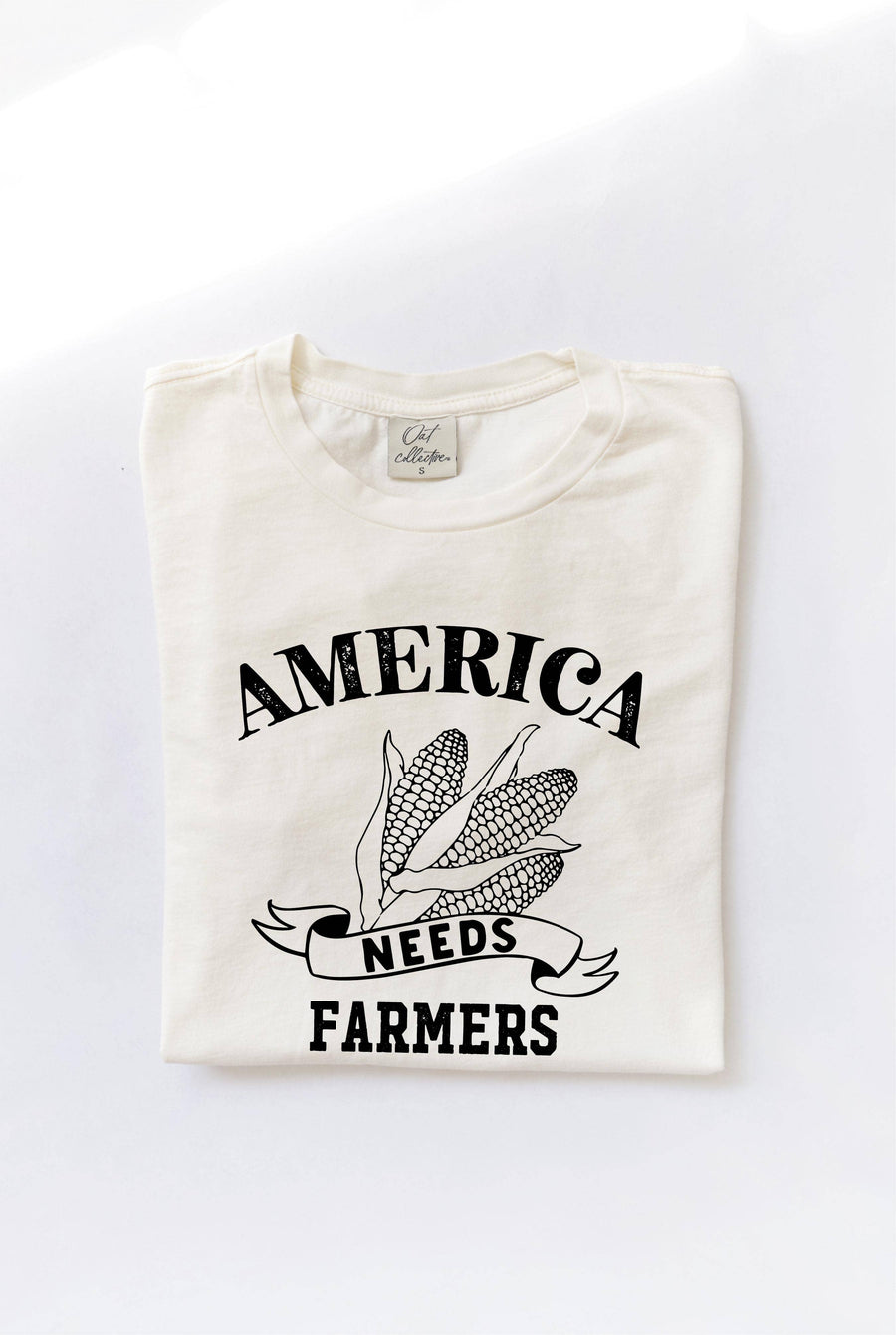 America Needs Farmers mineral washed graphic top in 100% premium cotton jersey. Features a relaxed unisex fit and screen-printed design with water-based ink. Each top is unique due to the dying process. Exclusive Oat Collective label.