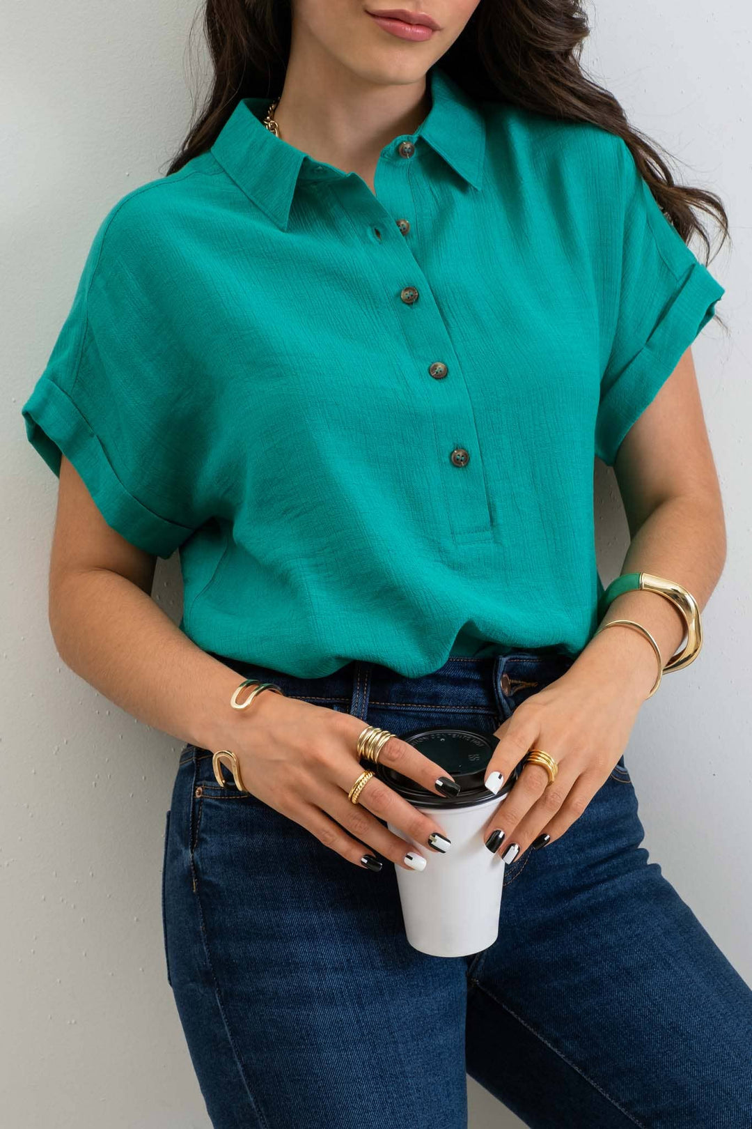 Tucked In View of Mid Button Down Woven Top with pointed collar, front functional buttons, folded cuff short sleeves, back yoke, and shirring detail. Made of 80% rayon and 20% nylon.